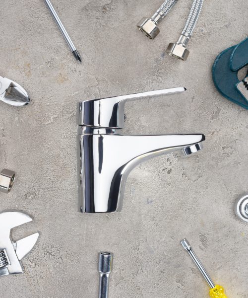 top view of water mixer surrounded with various tools on concrete surface
